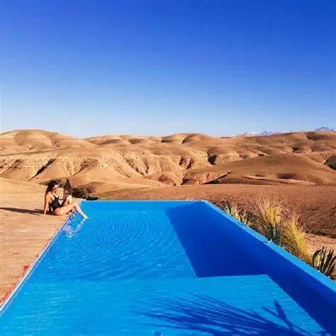 A swimming pool surrounded by tilework and palms in Marrakech